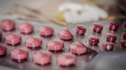 Cartelas de comprimidos rosados em destaque com fundo desfocado. — Foto: jarmoluk