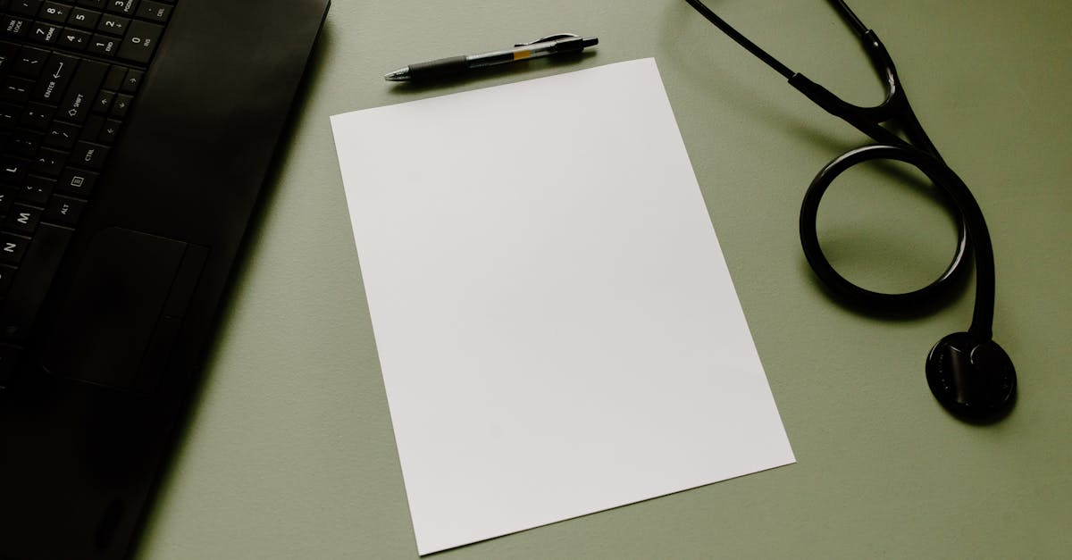Papel em branco sobre mesa com estetoscópio, caneta e parte de um notebook, representando ambiente médico e jurídico. — Foto: Tara Winstead