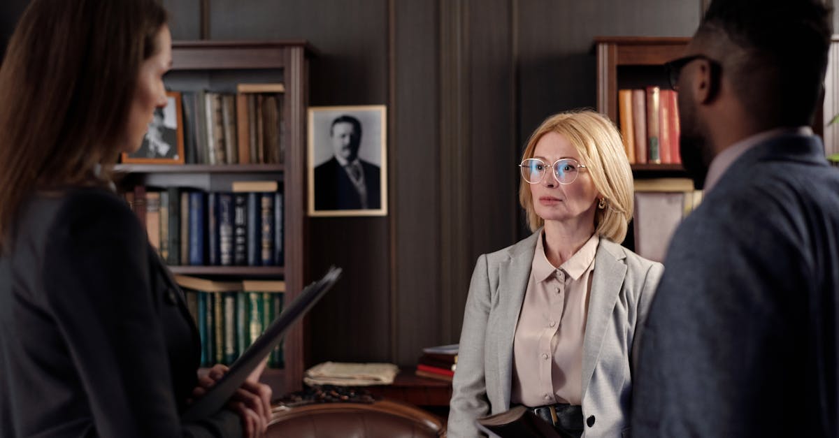 Três advogados em reunião profissional dentro de um escritório jurídico com estantes de livros ao fundo. — Foto: August de Richelieu