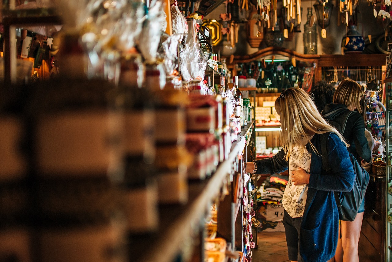 Reforma tributaria 2026 o que muda no seu bolso e nas compras 85790 1777201636 Mulher loira observando produtos em prateleiras de uma loja de conveniência ou empório. — foto: kasjanf