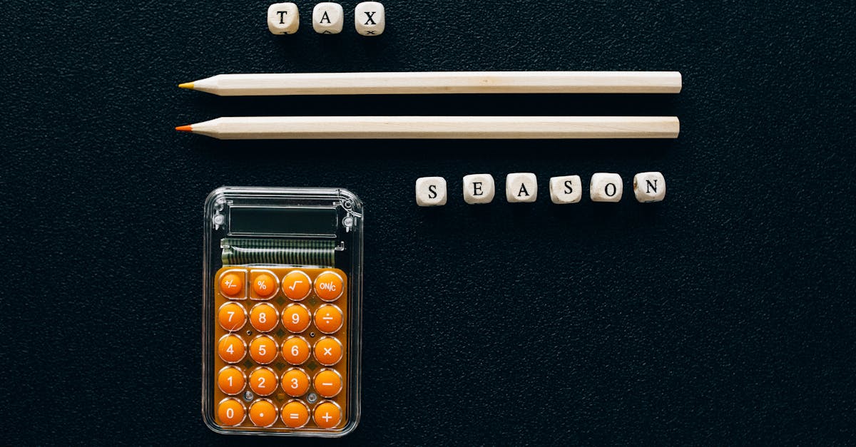 Vista superior de uma calculadora laranja, lápis e blocos com a escrita Tax Season sobre fundo preto. — Foto: Nataliya Vaitkevich