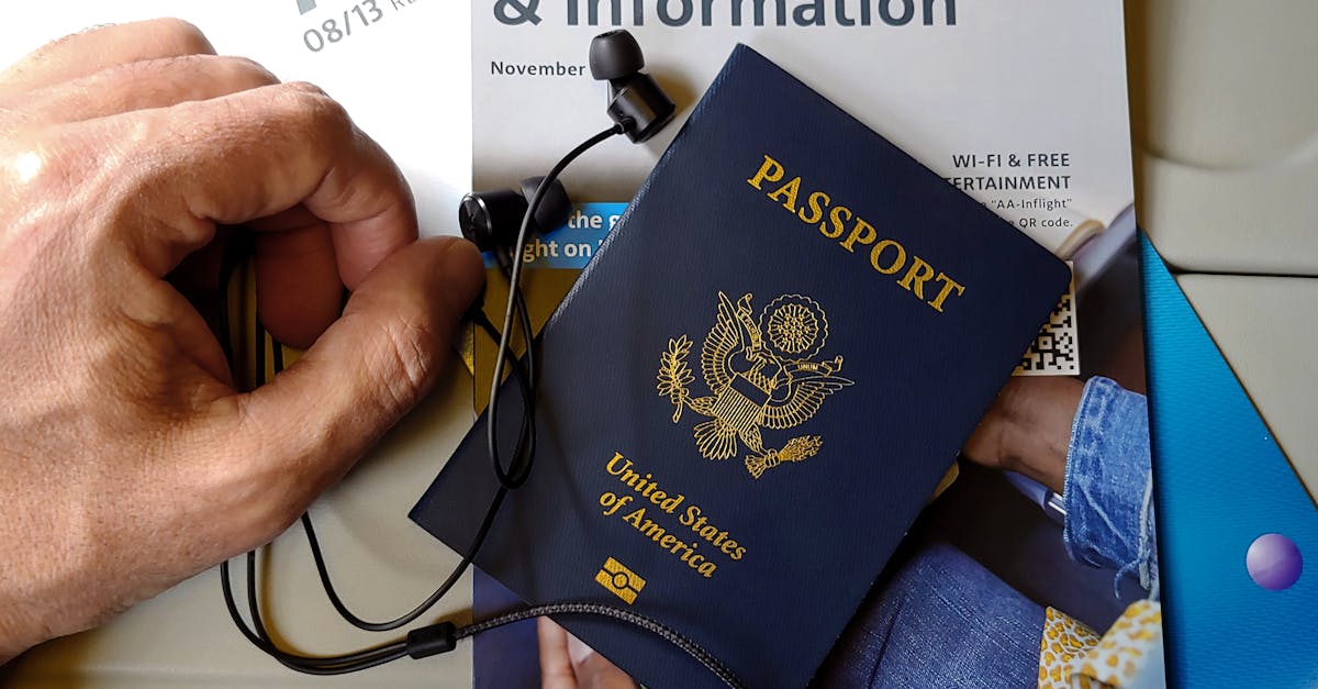 Mão segurando um passaporte dos Estados Unidos sobre documentos de viagem e fones de ouvido. — Foto: DΛVΞ GΛRCIΛ