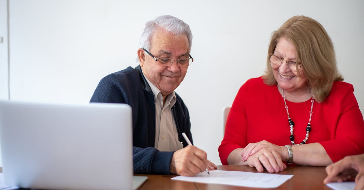 Aposentadoria em 2026 novas idades e regras de transicao 86582 1777806353 Casal de idosos sorridentes assinando papéis em uma mesa com notebook em ambiente de escritório. — foto: kampus production