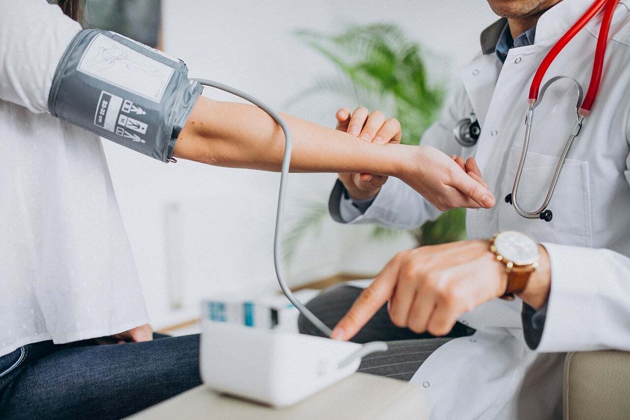 Médico e paciente em uma consulta médica, com equipamento de pressão arterial. — Foto: kumarsu6745_
