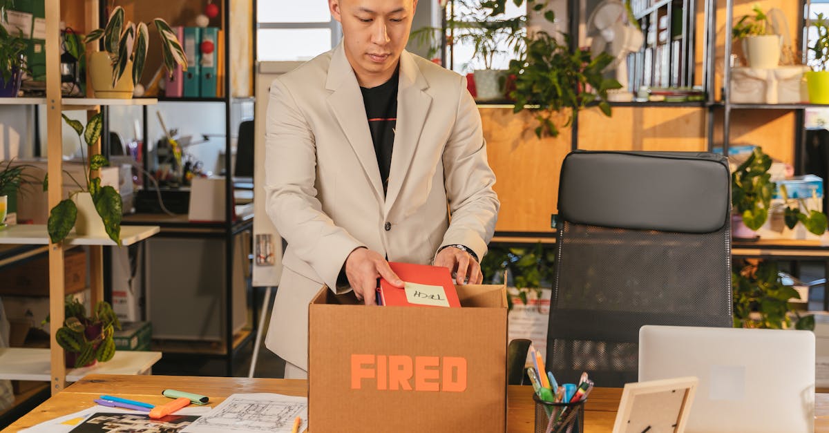 Homem de terno organizando seus pertences em uma caixa de papelão em um escritório. — Foto: ANTONI SHKRABA production