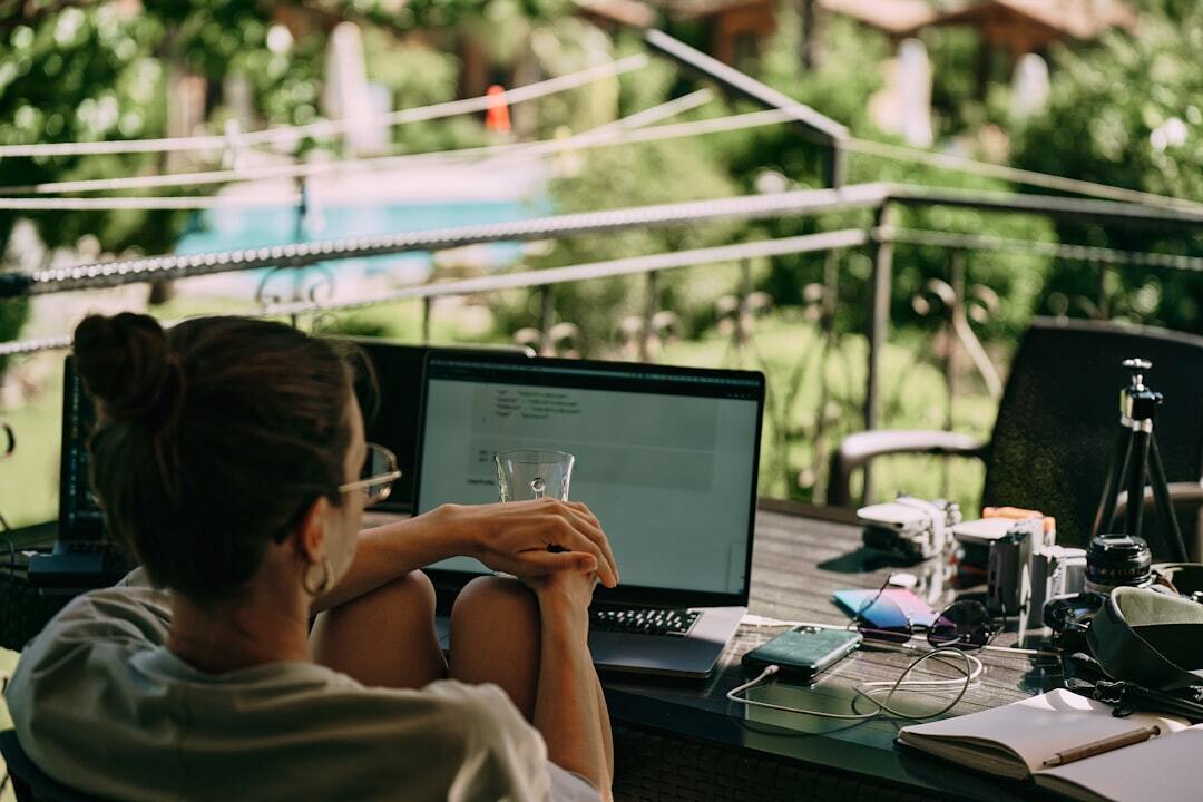 Pessoa trabalhando em um notebook em uma varanda com vista externa, representando um nômade digital. — Foto: Aleh Tsikhanau