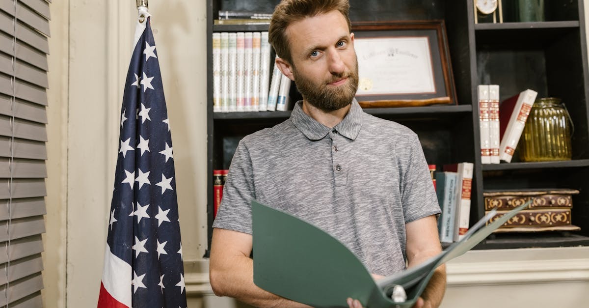 Homem segurando uma pasta de documentos em um escritório com uma bandeira dos Estados Unidos ao fundo. — Foto: RDNE Stock project