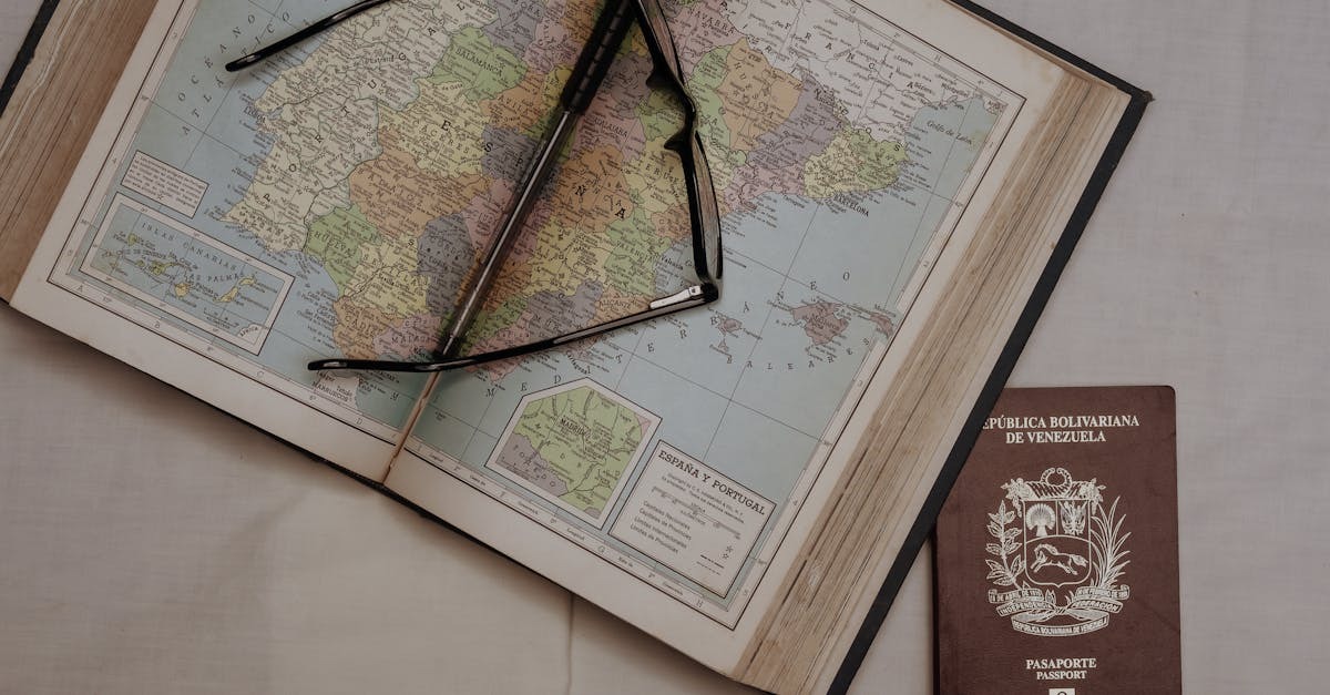 Passaporte sobre um mapa aberto com óculos de leitura em cima. — Foto: Arturo Añez.