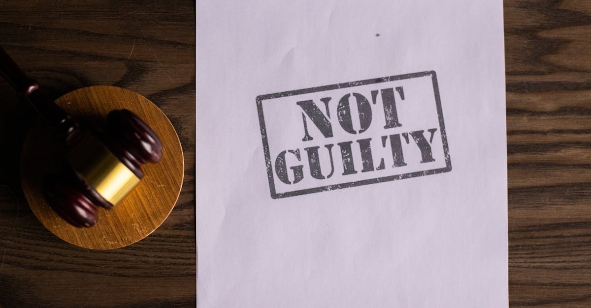 Martelo de juiz ao lado de uma folha de papel com o carimbo Not Guilty sobre uma mesa de madeira. — Foto: KATRIN BOLOVTSOVA