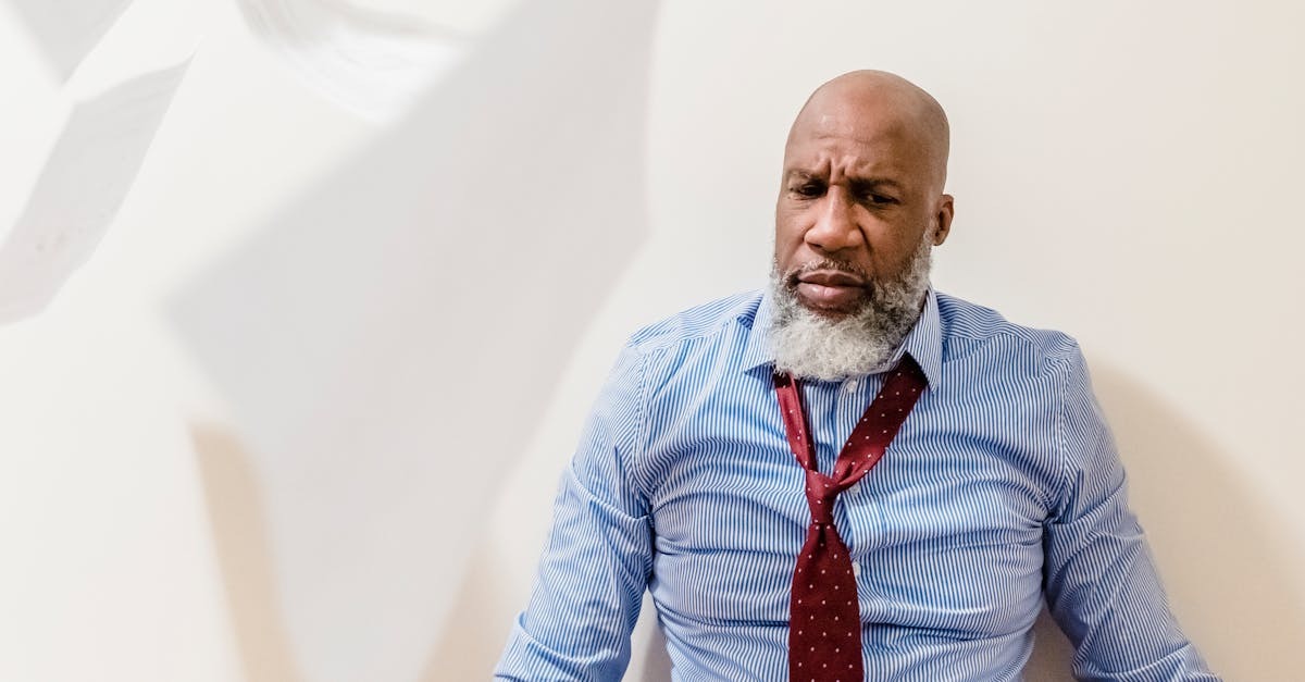 Homem negro de meia-idade com barba grisalha, vestindo camisa social e gravata frouxa, com expressão de preocupação. — Foto: Nicola Barts