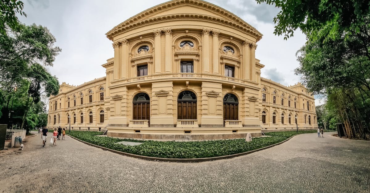Fachada de prédio histórico com arquitetura clássica cercado por jardins. — Foto: Mak Cézar