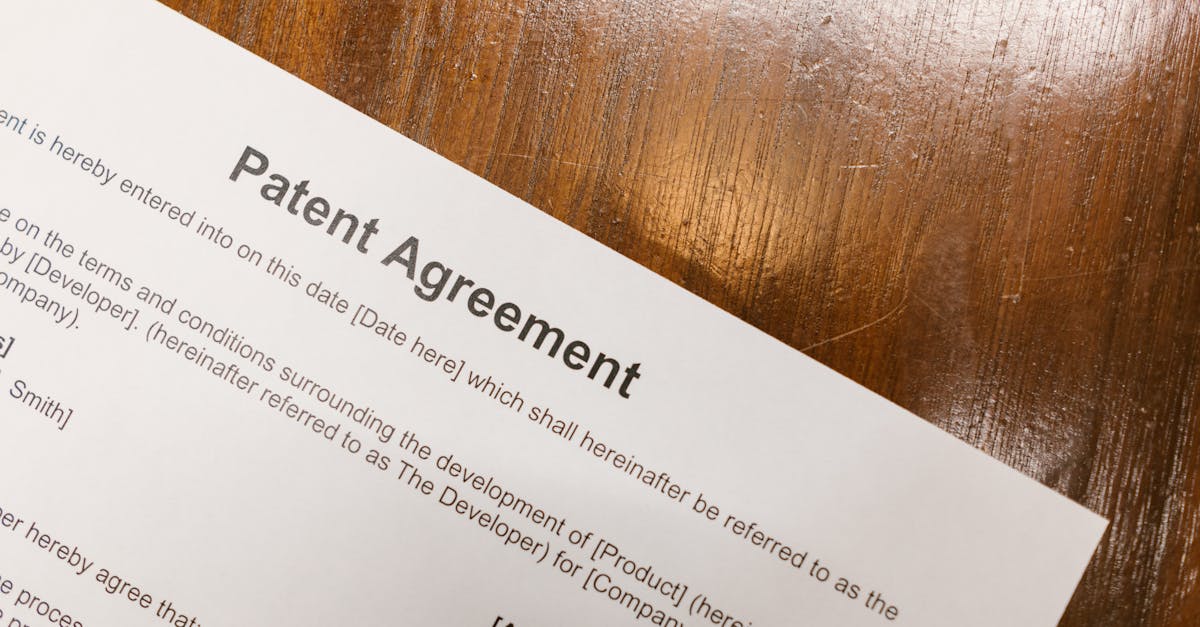 Close-up de um documento impresso intitulado Patent Agreement sobre uma mesa de madeira. — Foto: RDNE Stock project