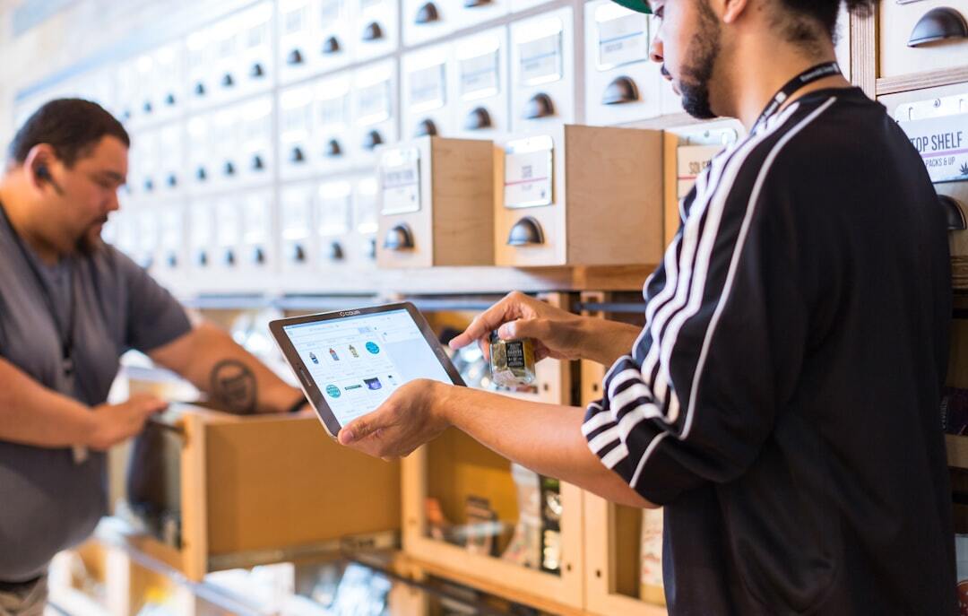 Homem usando tablet para verificar informações em um sistema de organização de produtos em um ambiente de trabalho. — Foto: Cova Software