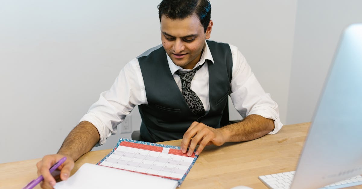 Homem em vestimenta formal revisando documentos em uma mesa de escritório. — foto: rdne stock project