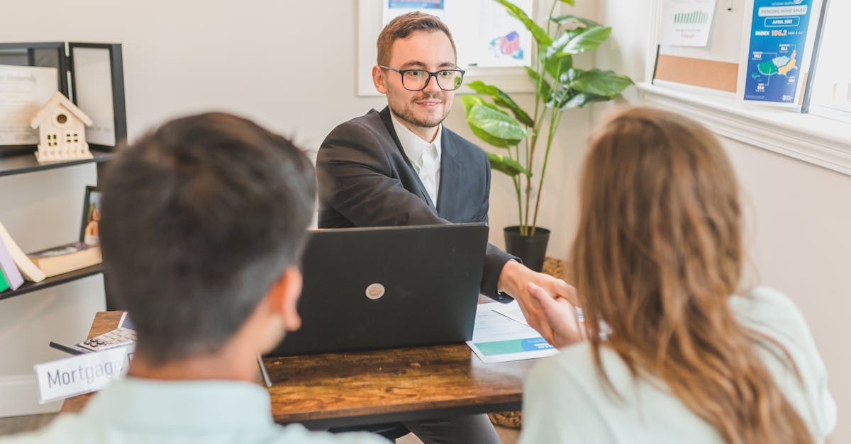 Homem em terno discutindo com duas pessoas em frente a um laptop em escritório. — Foto: RDNE Stock project