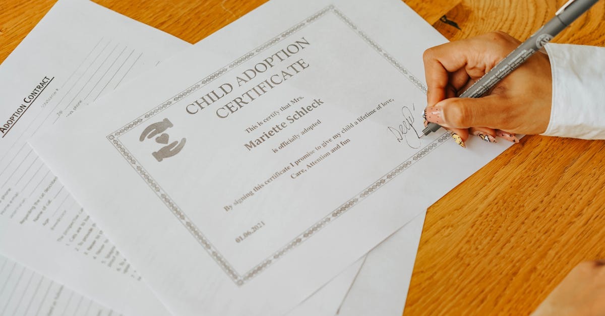 Pessoa assinando certificado de guarda de filhos em mesa de escritório — Foto: olia danilevich