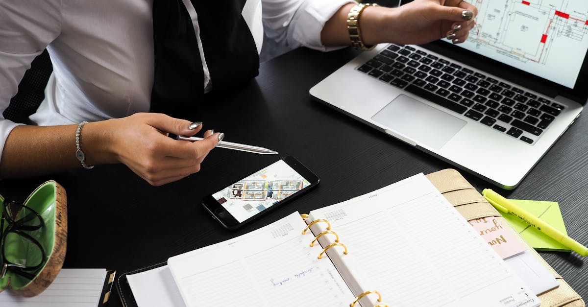 Profissional trabalhando em mesa de escritório com notebook, smartphone e agenda aberta. — Foto: energepic.com