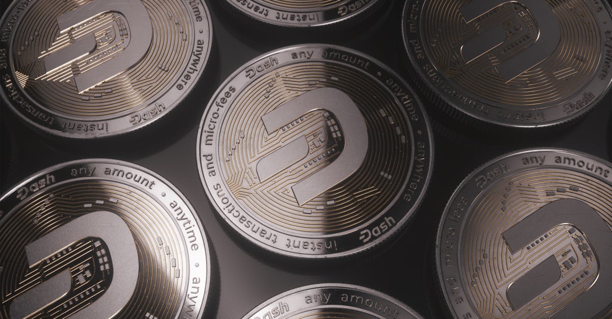 Close-up de várias moedas físicas da criptomoeda Dash sobre uma superfície escura. — Foto: Dash Cryptocurrency