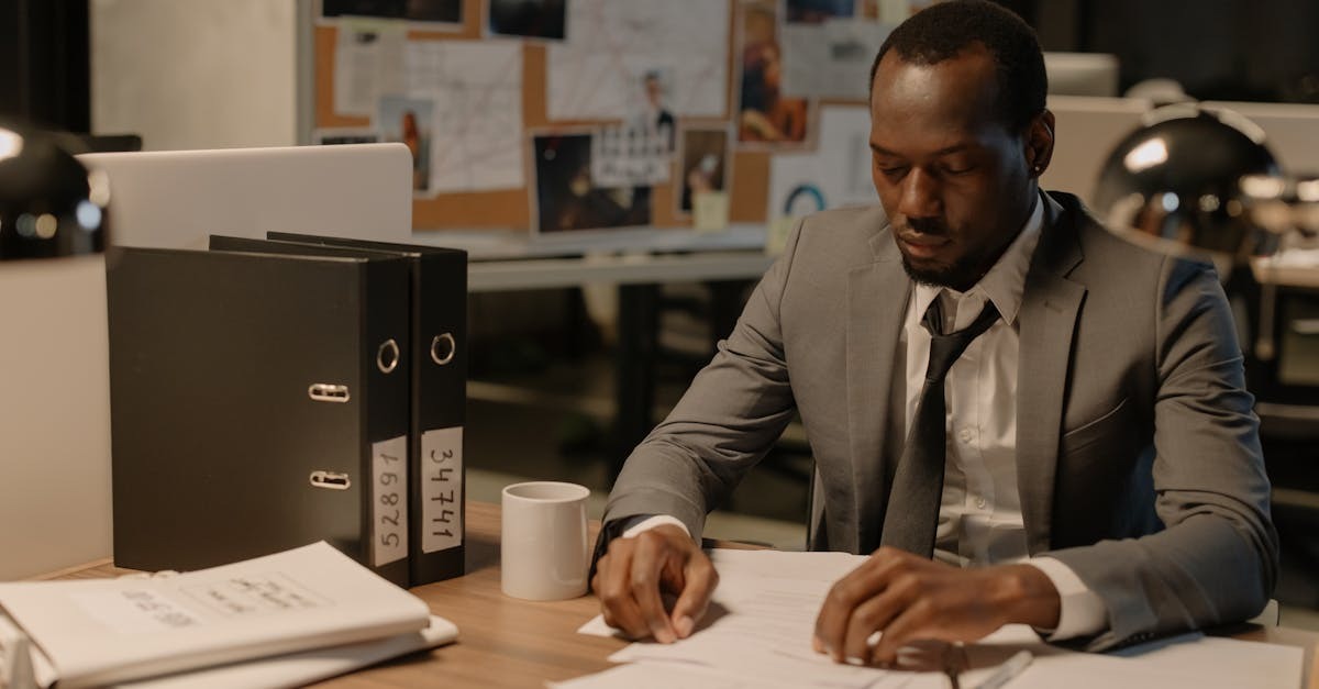Homem em terno analisando documentos em uma mesa de trabalho. — Foto: cottonbro studio