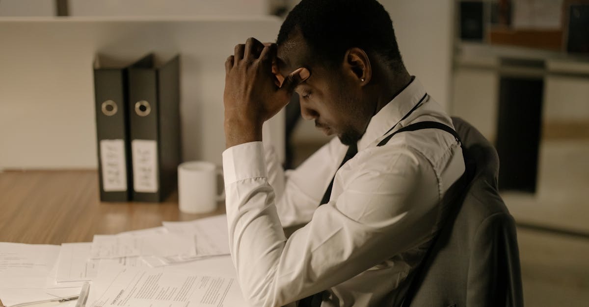 Homem cansado em frente a documentos em escritório — Foto: cottonbro studio