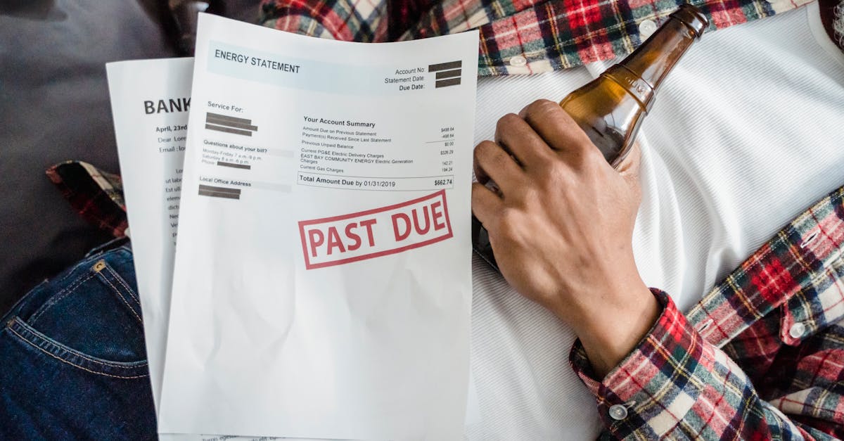 Pessoa deitada segurando uma garrafa de cerveja e faturas com carimbo de pagamento atrasado. — Foto: Nicola Barts