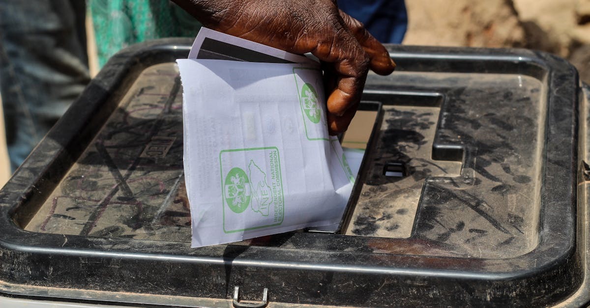 Mão depositando cédulas de voto em urna eleitoral. — Foto: Fatima Yusuf