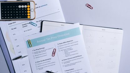 Documentos de planejamento tributário sobre uma mesa com calculadora de celular, caneta e clipes de papel. — Foto: Leeloo The First