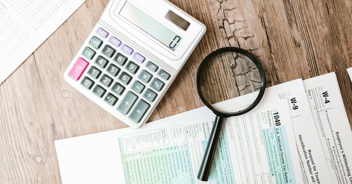 Calculadora e documentos financeiros sobre uma mesa de madeira. — Foto: RDNE Stock project