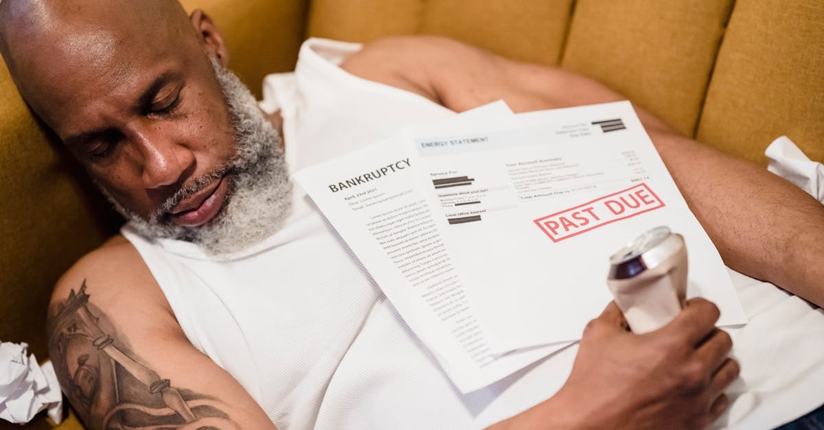 Homem dormindo com documentos financeiros e notificação de pagamento atrasado em sua mão. — Foto: Nicola Barts
