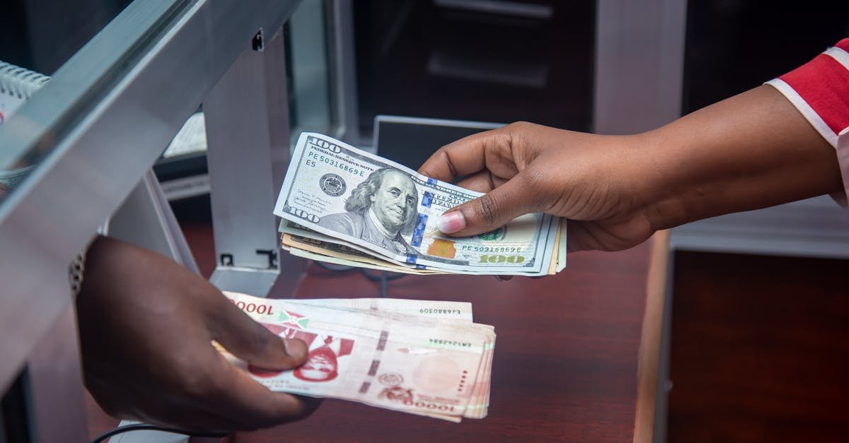 Mãos trocando notas de dólar em um guichê de atendimento bancário. — Foto: Audy of Course