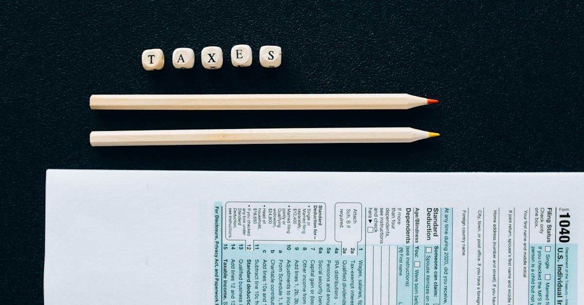 Formulário de imposto dos EUA com lápis e cubos de letras 'TAXES' sobre uma superfície escura. — Foto: Nataliya Vaitkevich