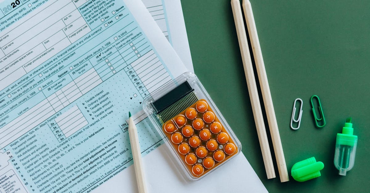 Papelada e calculadora em uma mesa, com canetas e clipes, sugerindo trabalho administrativo ou financeiro. — Foto: Nataliya Vaitkevich