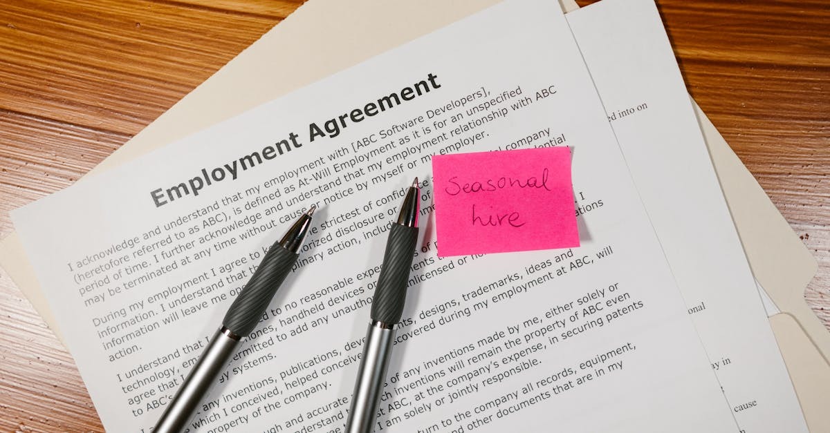Documentos de contrato de emprego com canetas e nota adesiva em uma mesa de madeira. — Foto: RDNE Stock project