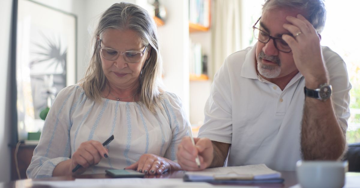 Homem e mulher em reunião, discutindo documentos em uma mesa. — foto: kampus production