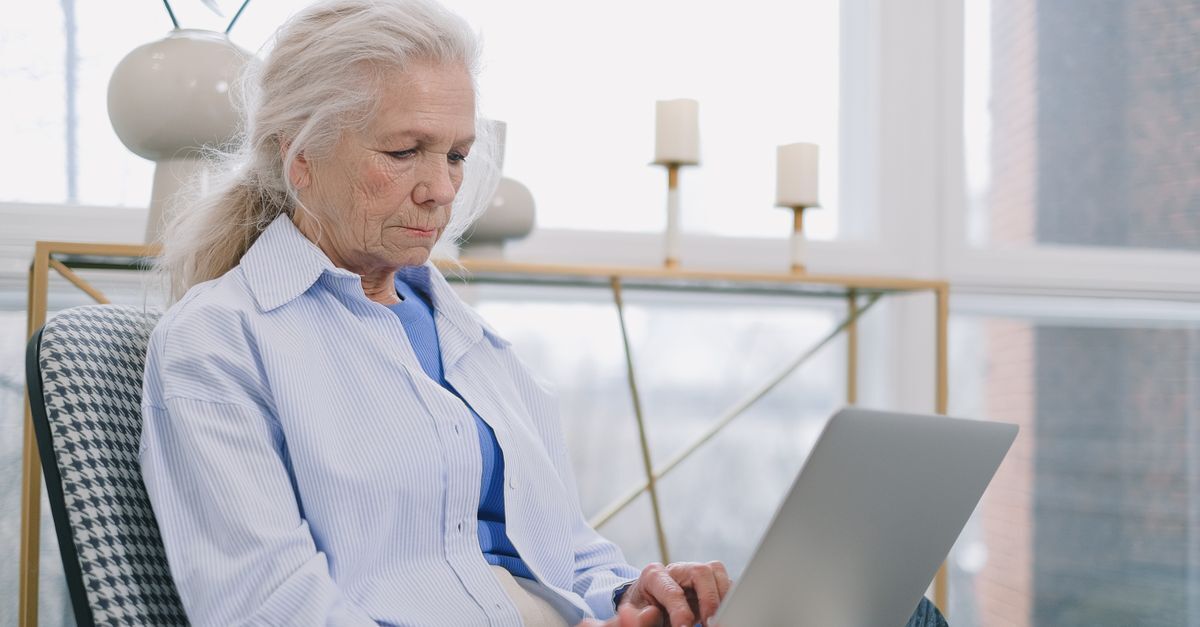 Mulher idosa analisando um laptop em um ambiente de trabalho. — foto: shvets production