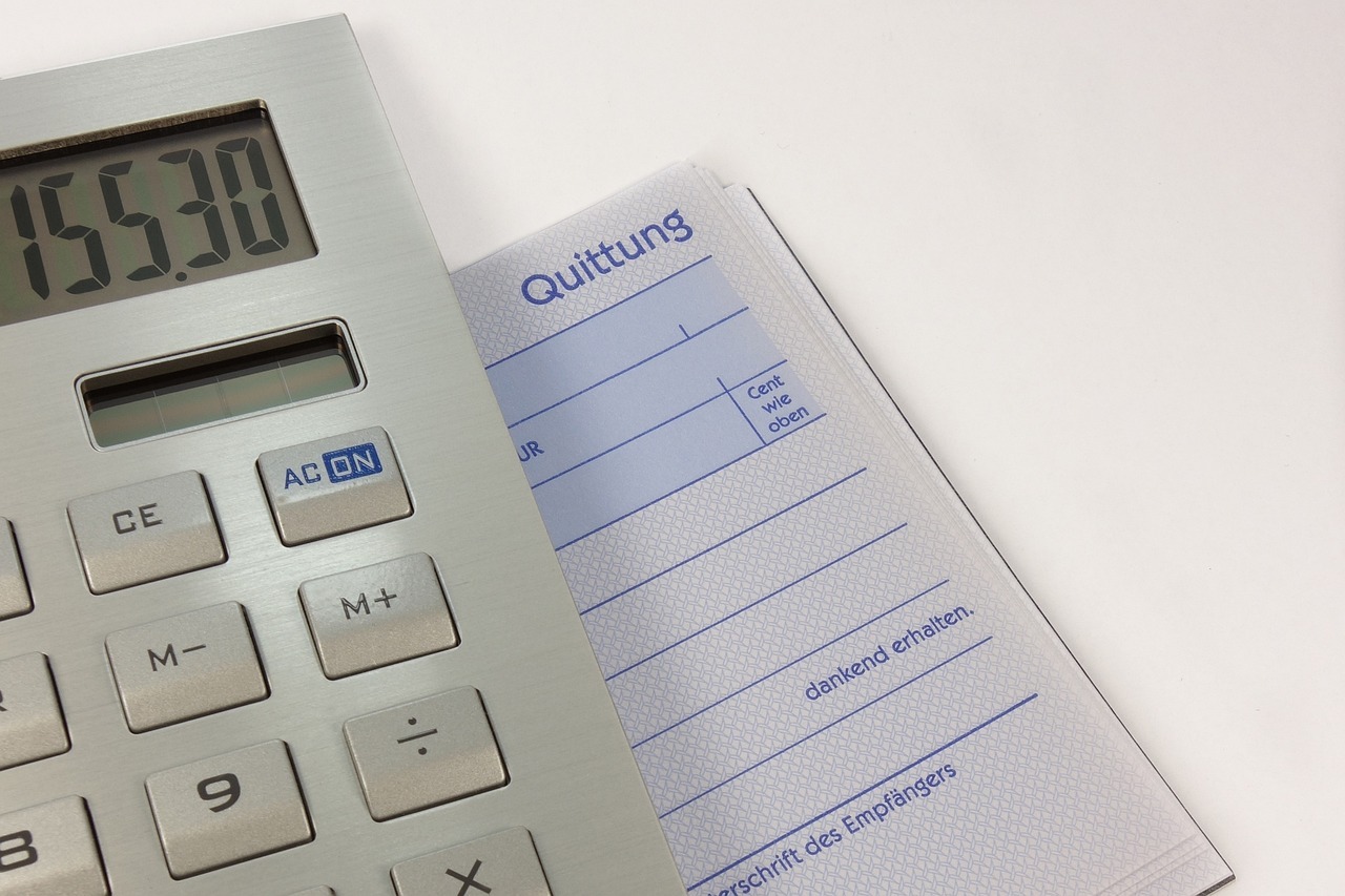 Calculadora e papel com texto em alemão sobre quitung. — foto: blickpixel