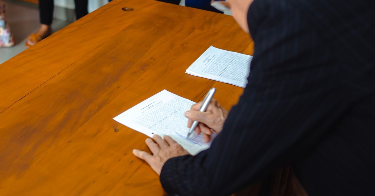Company formation for foreigners in brazil inline 1 170771 1780839170 Pessoa escrevendo em documentos em uma mesa de madeira. — foto: matheus lara