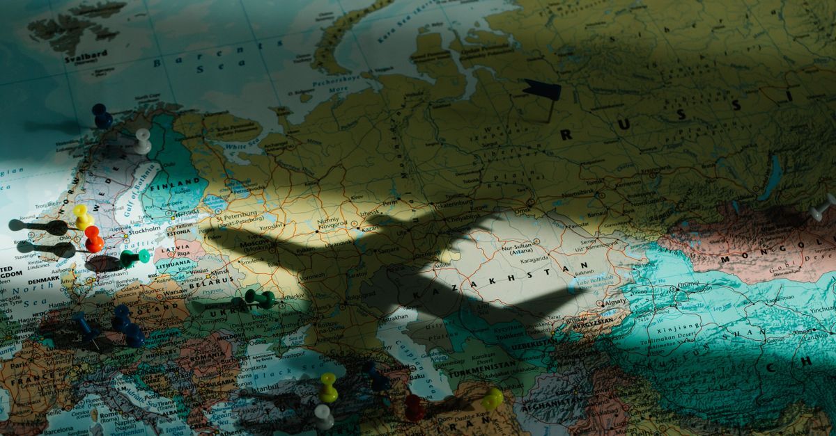 Mapa mundial com marcadores e sombra de avião, indicando discussão sobre questões internacionais. — foto: lara jameson