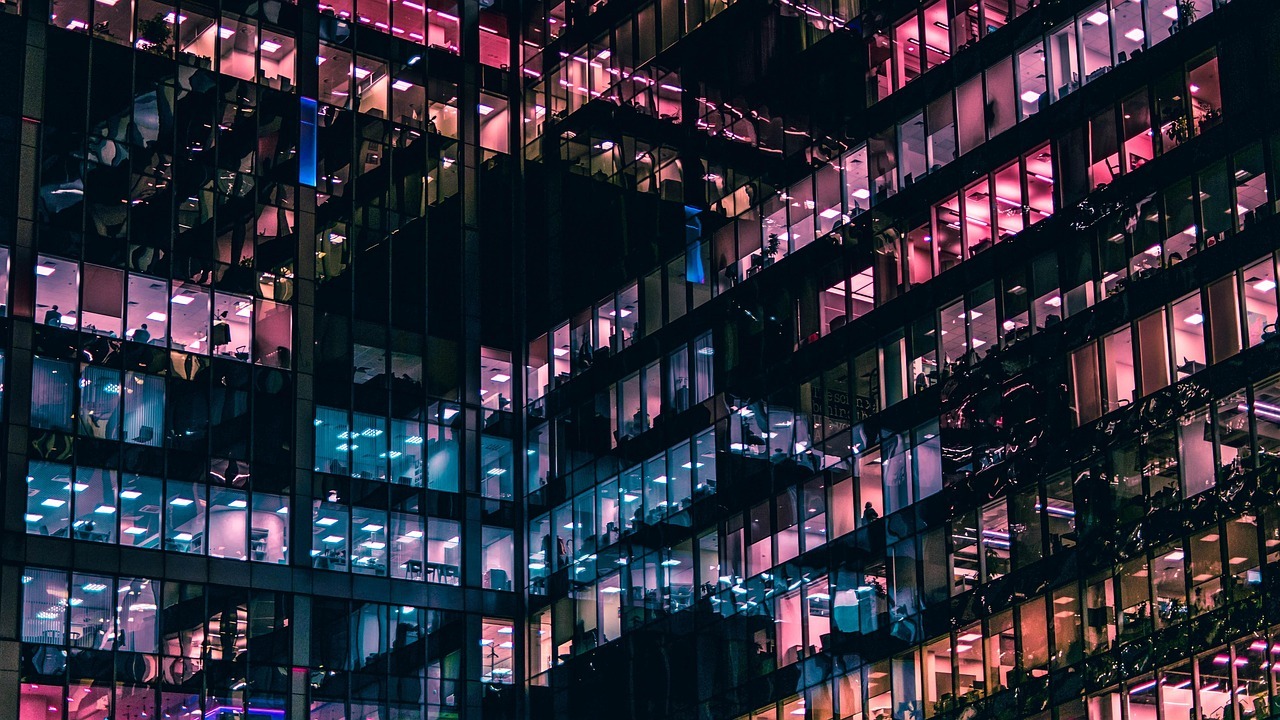 Edifício de escritório moderno com janelas iluminadas, simbolizando ambiente profissional e negócios. — foto: barbaracascao