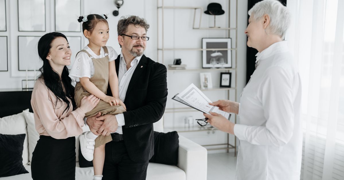 Família conversando com um homem em uma sala, possivelmente um advogado, em um ambiente doméstico. — foto: pavel danilyuk