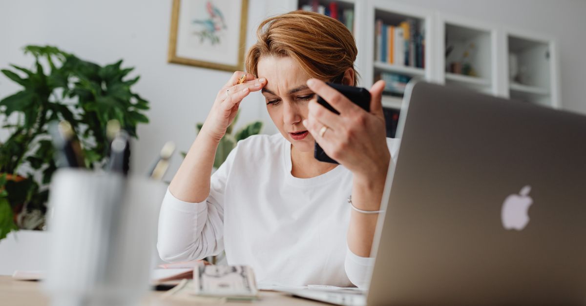 Superendividamento e golpes digitais seus direitos em 2026 inline 1 235388 1781861663 Mulher estressada com celular e laptop em um escritório. — foto: www. Kaboompics. Com