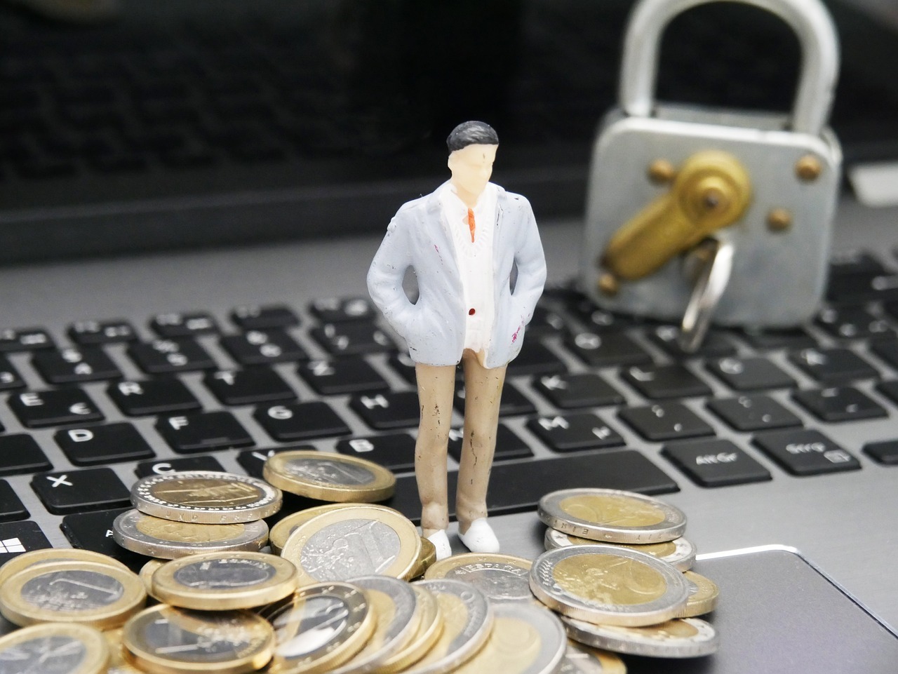 Superendividamento e golpes digitais seus direitos em 2026 inline 2 235388 1781861674 Homem de negócios em frente a moedas e cadeado em laptop — foto: schluesseldienst