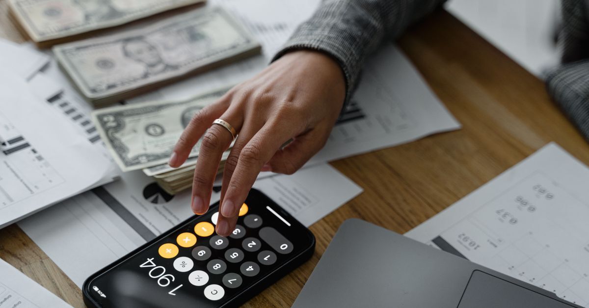 Aposentadoria em 2026 entenda as novas regras de transicao inline 2 479168 1785065862 Mão usando celular como calculadora com dinheiro e documentos em uma mesa.