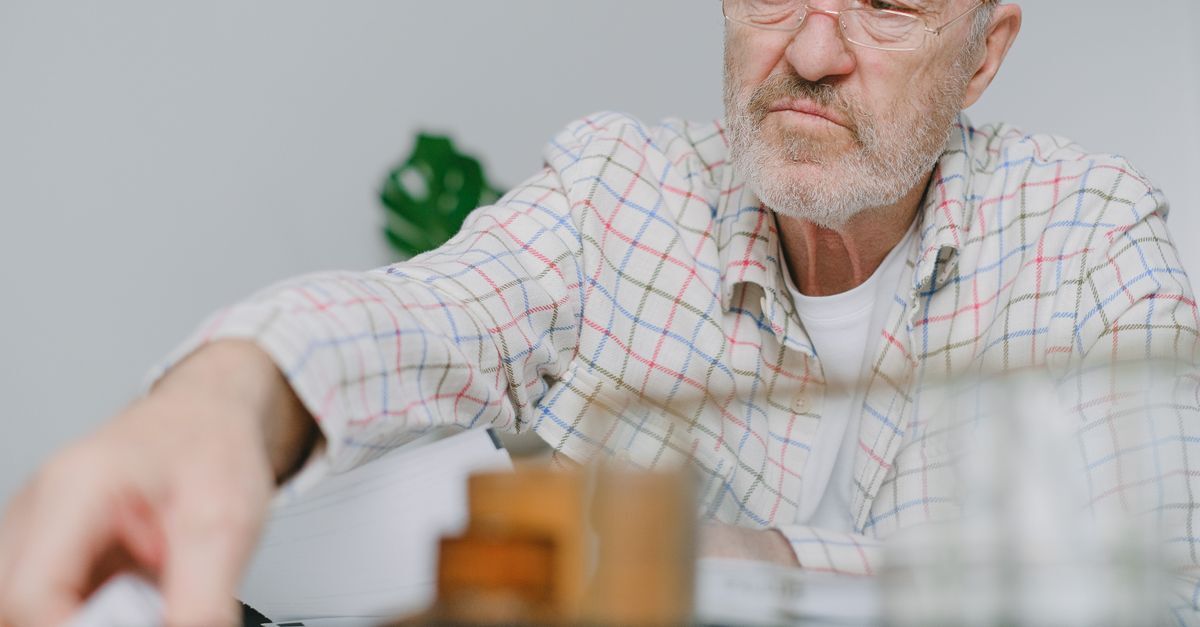 Aposentadoria em 2026 veja as novas idades e regras de transicao inline 1 446901 1784540224 Homem idoso em frente a uma mesa com objetos, possivelmente em um ambiente de trabalho.