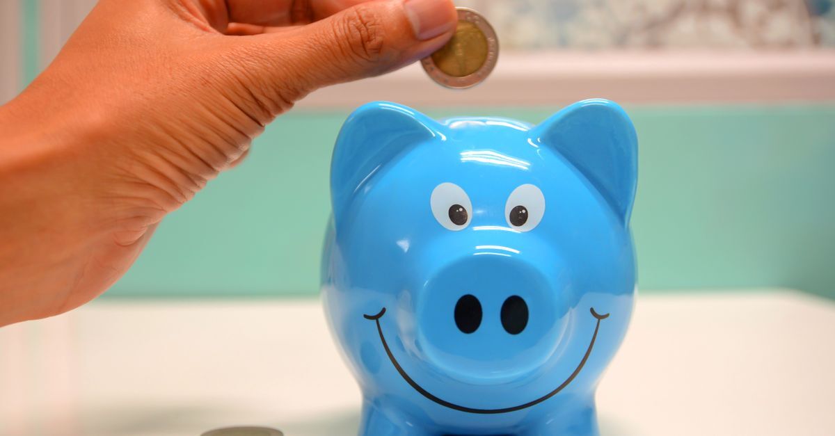 Apropriacao indebita previdenciaria inline 1 422236 1784131537 Mão depositando moeda em cofrinho azul com rosto feliz.