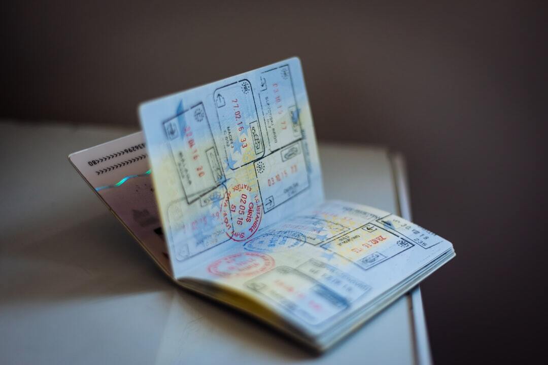 Brazil residence permit for saudi families and investors inline 2 430299 1784219961 Passaporte aberto sobre uma mesa exibindo diversas páginas com carimbos de imigração e vistos de viagem.
