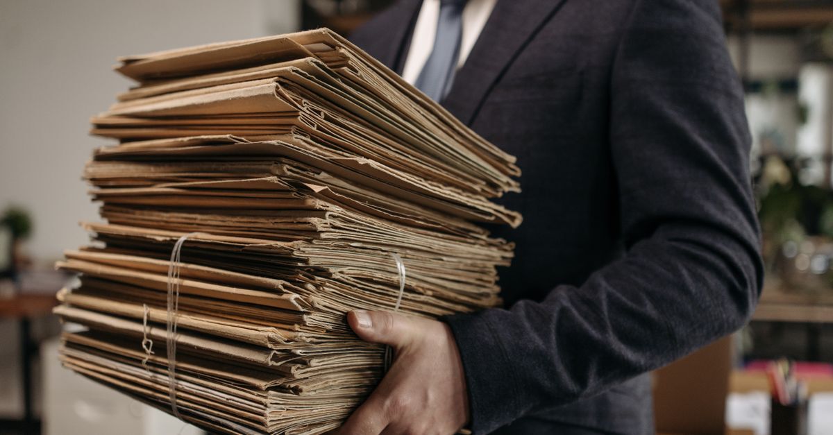 Brazilian residency and future passport pathway for turkish business owners inline 1 379564 1783615158 Homem segurando pilha de documentos amarrados em ambiente de trabalho.