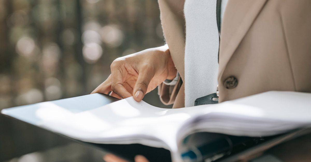 Pessoa revisando documentos em ambiente profissional