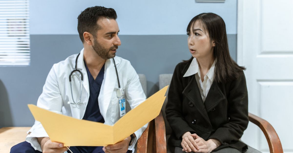 Médico e paciente discutindo informações médicas em uma sala de espera.