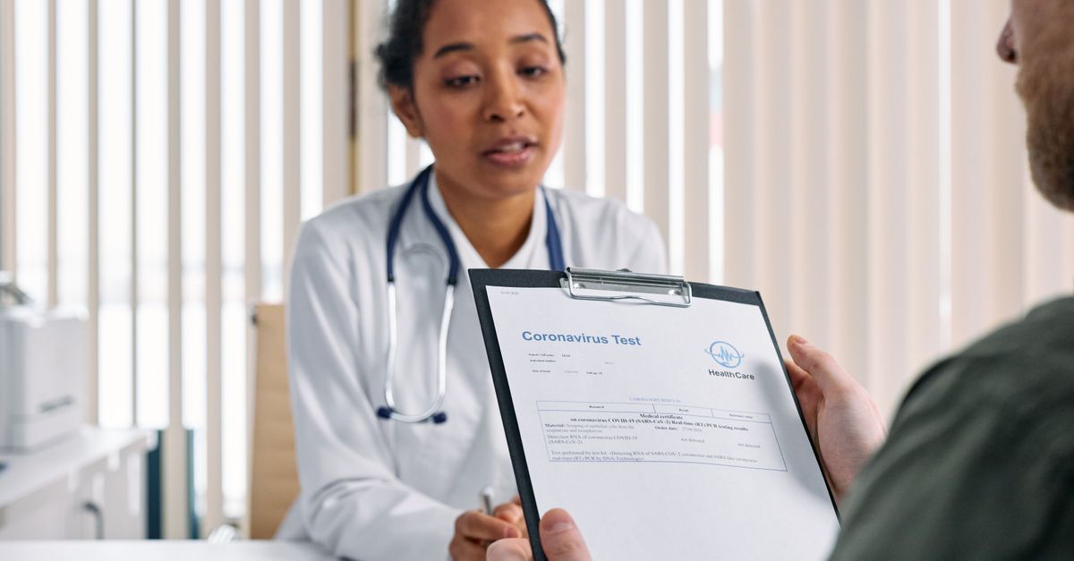 Médica e paciente discutindo documentos em um ambiente de escritório.